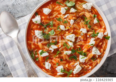 Traditional Greek pasta kritharaki or orzo with spicy tomato sauce, cheese, garlic, onion, carrots closeup on the plate. Horizontal top view 116429365