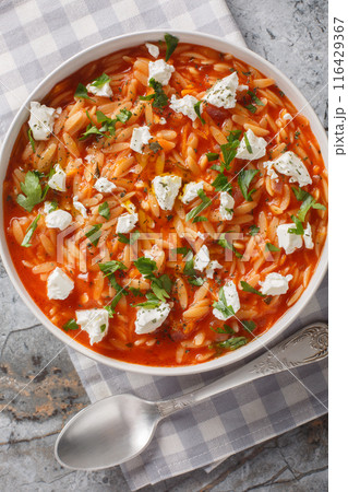 One-pot Greek orzo kritharaki with tomatoes and Feta cheese is a delicious weeknight dish and a comfort food in Greece closeup on the plate. Vertical top view One-pot Greek orzo kritharaki with tomatoes and Feta cheese is a delicious weeknight dish and a comfort food in Greece closeup on the plate. Vertical top view 116429367