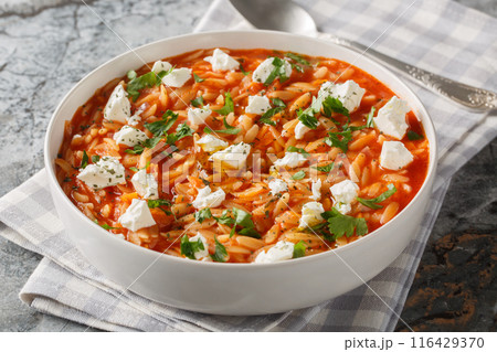 Delicious vegetarian food pasta kritharaki or orzo with spicy tomato sauce, cheese, garlic, onion, carrot closeup on the plate. Horizontal 116429370