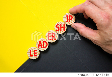 Leadership symbol. Concept word Leadership on beautiful wooden circles. Beautiful yellow and black background. Businessman hand. Business leadership concept. Copy space. 116431416