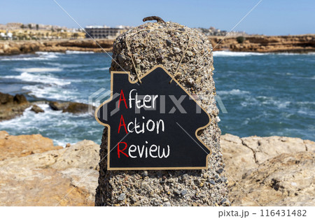 AAR After action review symbol. Concept words AAR After action review on beautiful yellow blackboard. Beautiful stone blue sky sea background. Business AAR after action review concept. Copy space. 116431482