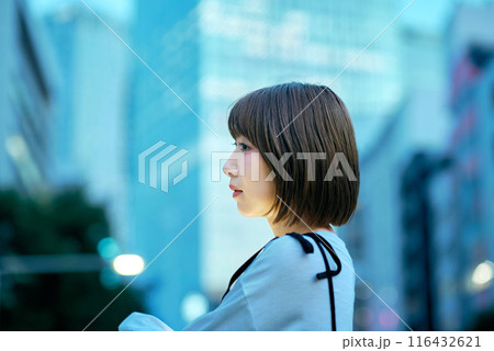 夕方の繁華街と若い女性 116432621