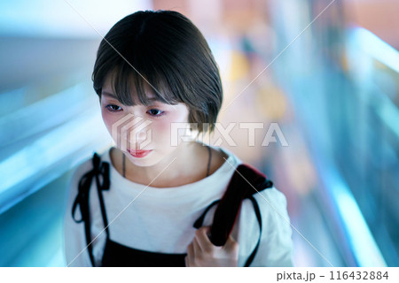 夜の繁華街を見つめる若い女性 夜の繁華街を見つめる若い女性 116432884