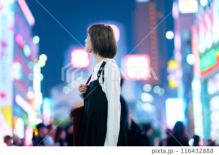 夜の繁華街を見つめる若い女性 夜の繁華街を見つめる若い女性 116432888