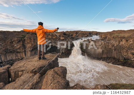 Traveler man enjoying with Aldeyjarfoss waterfall flowing among the Icelandic Highland in summer at Iceland 116432987