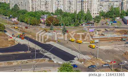 Asphalt paver, roller and truck on the road repair site during asphalting timelapse. Road construction equipment. Asphalt paver, roller and truck on the road repair site during asphalting timelapse. Road construction equipment. 116433365
