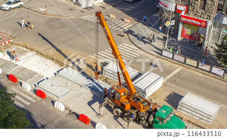 Installing concrete plates by crane at road construction site timelapse. 116433510