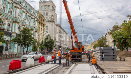 Installing concrete plates by crane at road construction site timelapse. 116433519