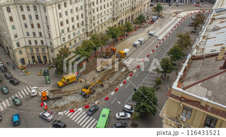 Orange construction telescopic crane loading old tram rails into truck timelapse. 116433521