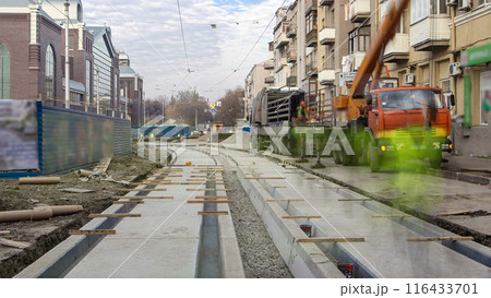 Tram rails at the stage of their unloading from truck by crane on concrete plates on the road timelapse. Tram rails at the stage of their unloading from truck by crane on concrete plates on the road timelapse. 116433701