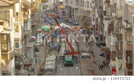 Unloading concrete plates from truck by crane at road construction site timelapse. 116433722