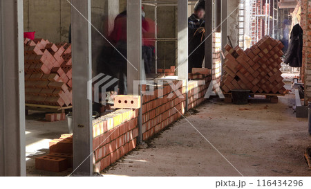 Bricklayers laying bricks to make a walls timelapse. 116434296