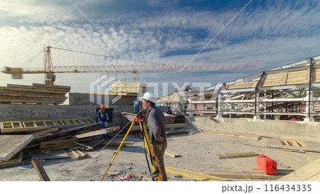 Construction worker using theodolite surveying optical instrument timelapse. 116434335