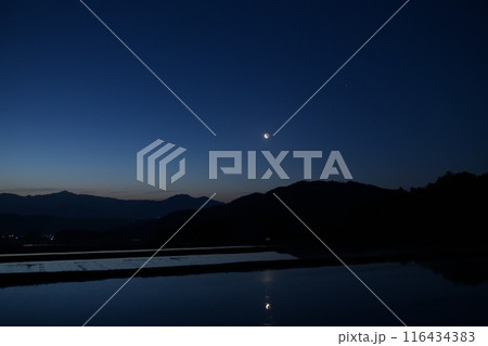 北杜市白州町、明け行く空に昇る地球照の細い月を映す田植前の水田 北杜市白州町、明け行く空に昇る地球照の細い月を映す田植前の水田 116434383