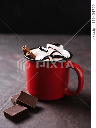 Red cup of aroma hot chocolate with marshmallows and cinnamon on a brown background. Red cup of aroma hot chocolate with marshmallows and cinnamon on a brown background. 116434799