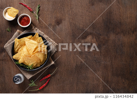 Traditional Mexican corn chips nachos with salsa and cream sauce, herbs, salt and chili pepper Traditional Mexican corn chips nachos with salsa and cream sauce, herbs, salt and chili pepper 116434842