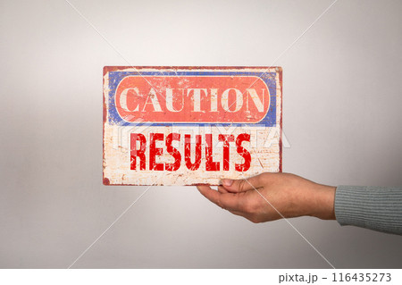 Results. Caution sign with text in woman hand on white background Results. Caution sign with text in woman hand on white background 116435273