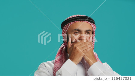 Muslim guy covers eyes, ears and mouth on camera, showing three wise monkeys metaphor symbol. Middle eastern person creating dont hear, see or speak concept sign, islamic attire. Muslim guy covers eyes, ears and mouth on camera, showing three wise monkeys metaphor symbol. Middle eastern person creating dont hear, see or speak concept sign, islamic attire. 116437021