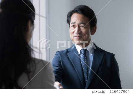 契約や商談などで握手するエグゼクティブなビジネスマン 116437904