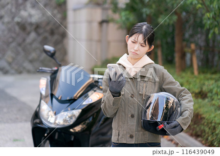 困った表情の女性バイカー 116439049