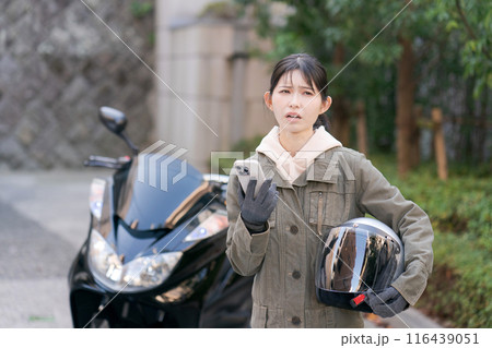 困った表情の女性バイカー 116439051