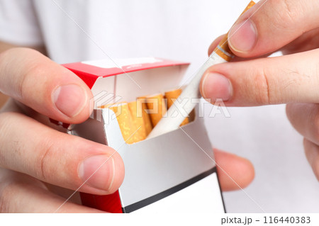 A pack of cigarettes in male hands on a light background 116440383