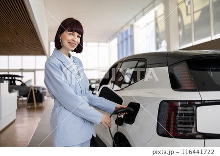 Businesswoman buys electric SUV at car dealership showroom 116441722