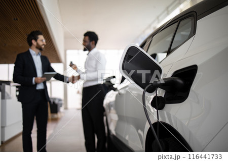 Dealer sells electric SUV to businessman in car dealership 116441733