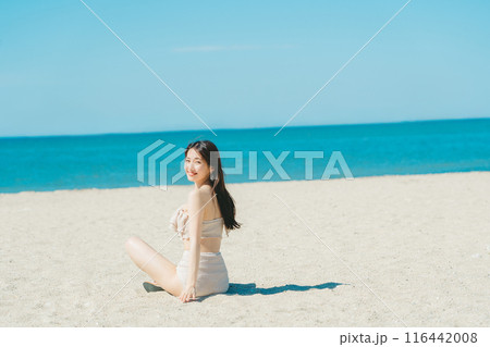 砂浜に座る水着の若い女性 砂浜に座る水着の若い女性 116442008