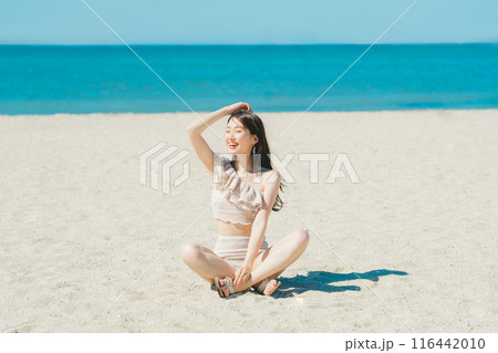 砂浜に座る水着の若い女性 116442010