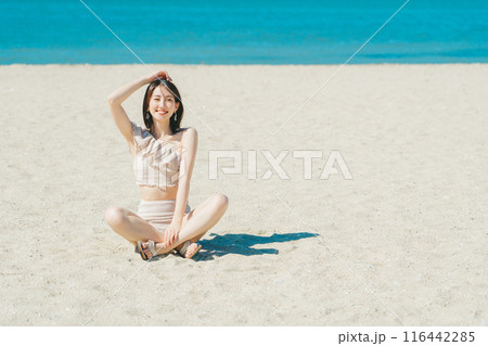 砂浜に座る水着の若い女性 砂浜に座る水着の若い女性 116442285
