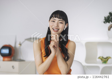 カメラ目線で話すイヤホンをつけた笑顔の若い女性 カメラ目線で話すイヤホンをつけた笑顔の若い女性 116442761