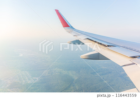 View from the airplane window at a beautiful cloudy sky and the airplane wing 116443559