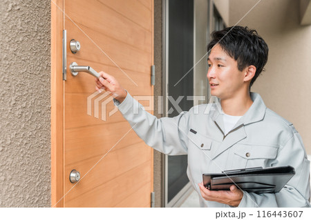 玄関ドアをチェックする工務店・ハウスメーカーの作業員の男性 116443607