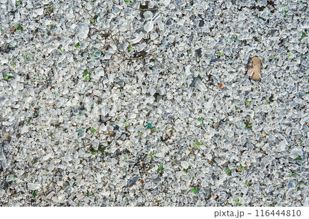 Many small pieces of broken shattered glass of different colors. 116444810
