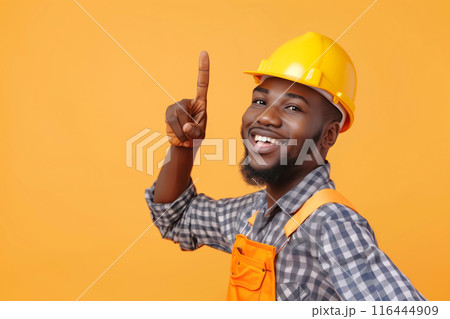 African American Repairman Pointing Upwards Against Yellow Background 116444909