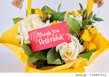 Thank You Veteran's Text on a red business card in a basket with fresh flowers Thank You Veteran's Text on a red business card in a basket with fresh flowers 116447372