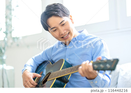 ギターを弾く若い男性 116448216