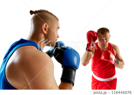 Two combat athletes engaged in sparring session, red competitor against blue competitor against white studio background. Two combat athletes engaged in sparring session, red competitor against blue competitor against white studio background. 116448876