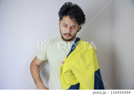 黄色い作業服を肩にかける男性 116450494