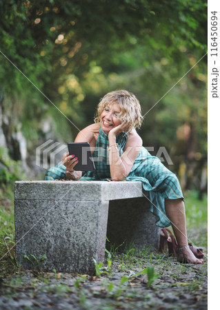 Woman reads a cheerful story from ebook Woman reads a cheerful story from ebook 116450694