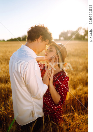 Portrait of young happy couple hugging on the field on the sunset. Enjoying time together. Portrait of young happy couple hugging on the field on the sunset. Enjoying time together. 116451815