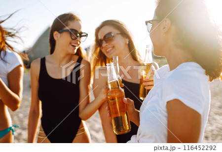 Happy Four girls dancing and drinking beers on the beach at sunset. Summer holidays, vacation. Happy Four girls dancing and drinking beers on the beach at sunset. Summer holidays, vacation. 116452292