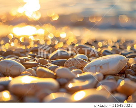 Beach pebbles, vibrant sunset, and a soft, warm water glow 116453323
