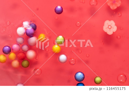 Colorful gel texture, clear skincare cream with bubbles and decorative figurines background, transparent beauty serum, colored cosmetic product close up 116455175