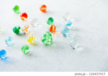 光を受けて輝く色とりどりのビー玉 116457417