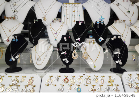 Necklaces and pendants on display in the window of a jewelry store 116459349
