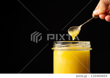 Natural ghee healthy lactose-free oil for frying, black background, copy space for text Natural ghee healthy lactose-free oil for frying, black background, copy space for text 116460664
