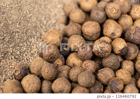 Ground black pepper and peppercorns close-up. Ground black pepper and peppercorns close-up. 116460792
