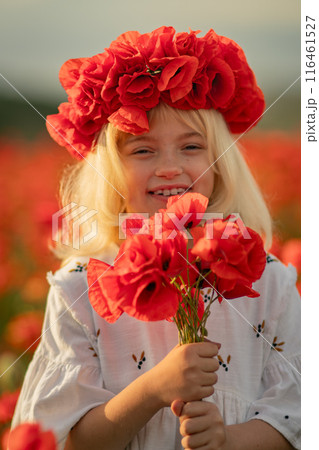 A young girl wearing a red flower headdress is holding a bouquet of red flowers 116461527